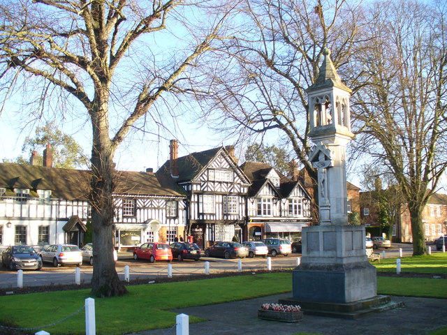 The war memorial on the green in Beaconsfield Old Town, with the black-and-white timbered buildings of the high street behind.