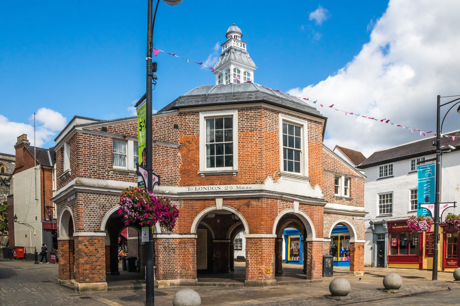 The octagonal red-brick Cornmarket building on High Wycombe High Street, with bunting strung across the street.