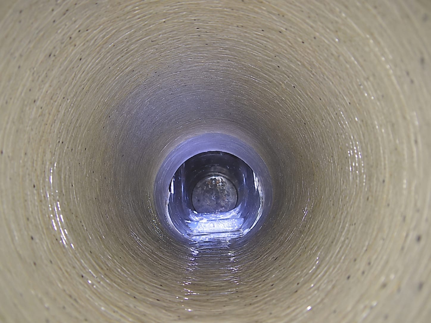 CCTV still of the same run after repair, the damaged joint covered by a cured resin patch liner forming a smooth, sealed bore.
