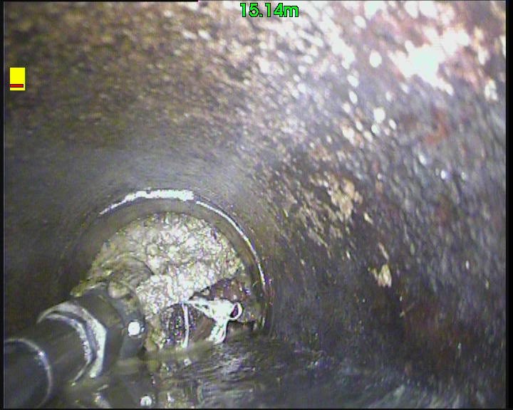 CCTV camera still showing a jetting nozzle at a debris blockage inside a pipe.
