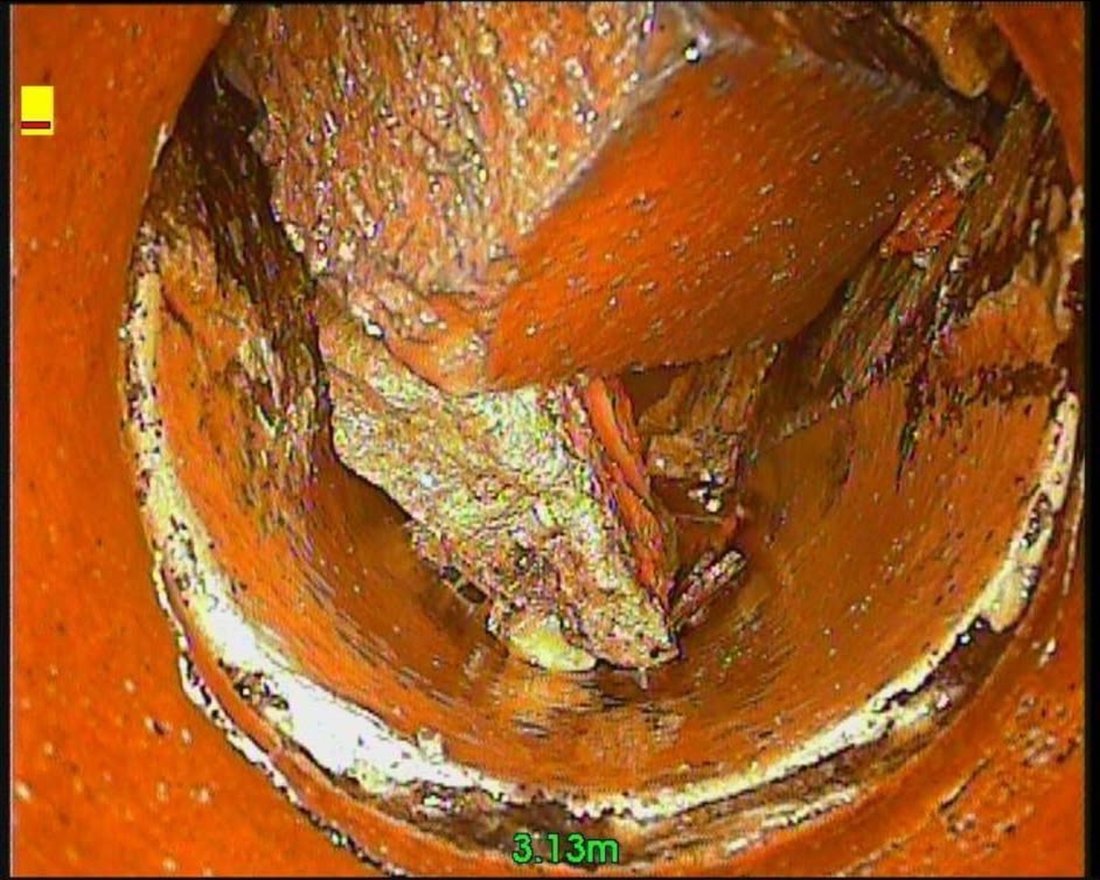 CCTV survey still of hardened fat and debris blocking a clay pipe just over three metres along the run.