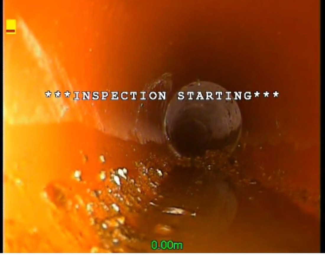 CCTV still from the start of a survey, the camera at zero metres inside an orange clay pipe with the inspection starting overlay on screen.
