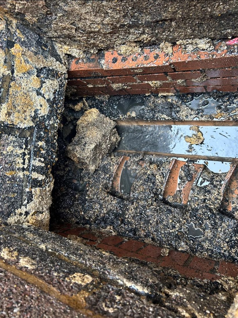 The inside of a brick chamber crusted over with congealed fat, a lump of it hanging off the wall above the waterline.